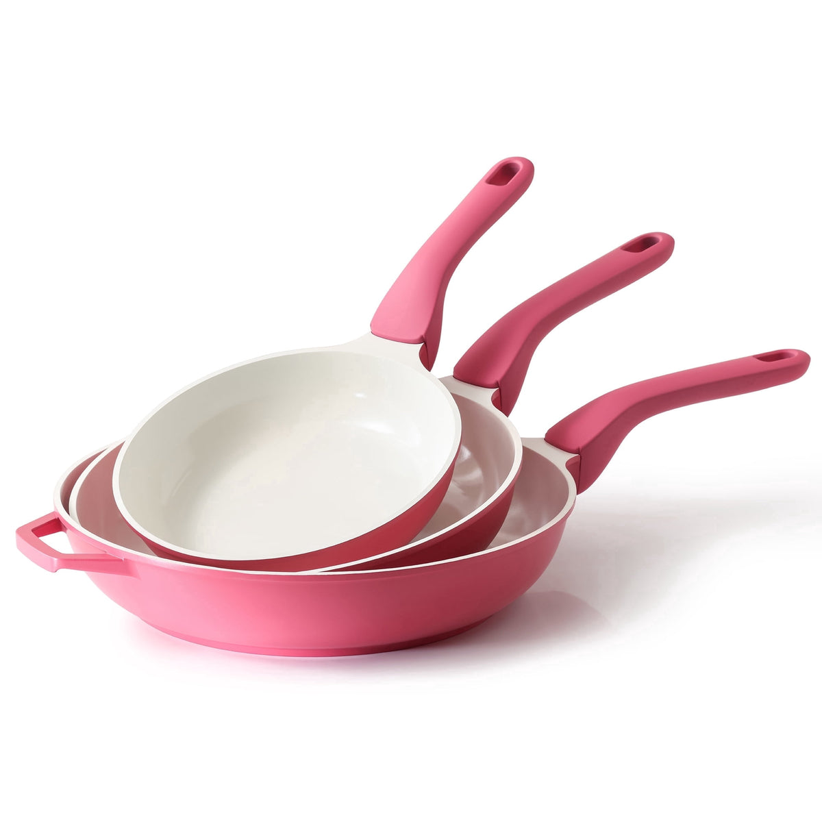 Three pink frying pans with light interiors and matching handles, stacked together.