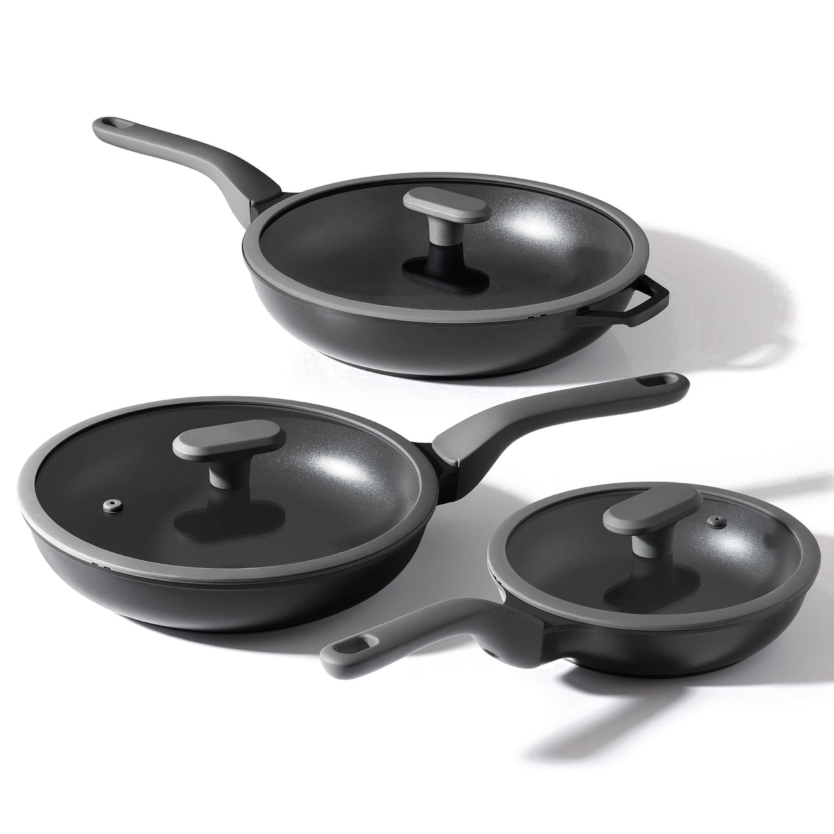Black three frying pans with three lids.