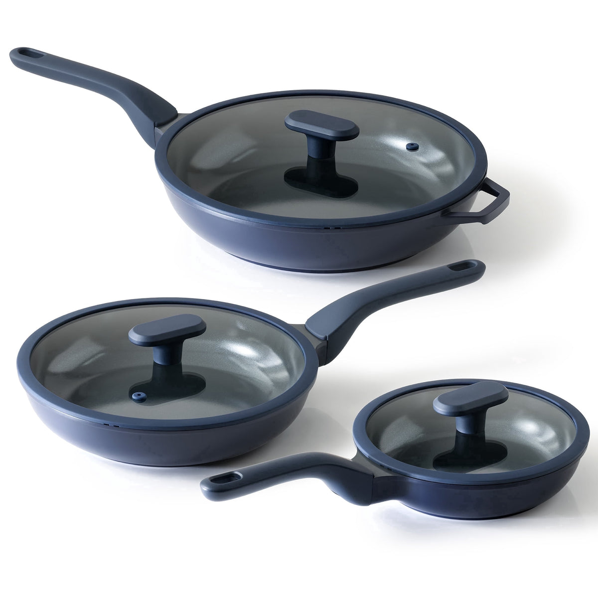 Three navy frying pans in different sizes, each with a clear lid.